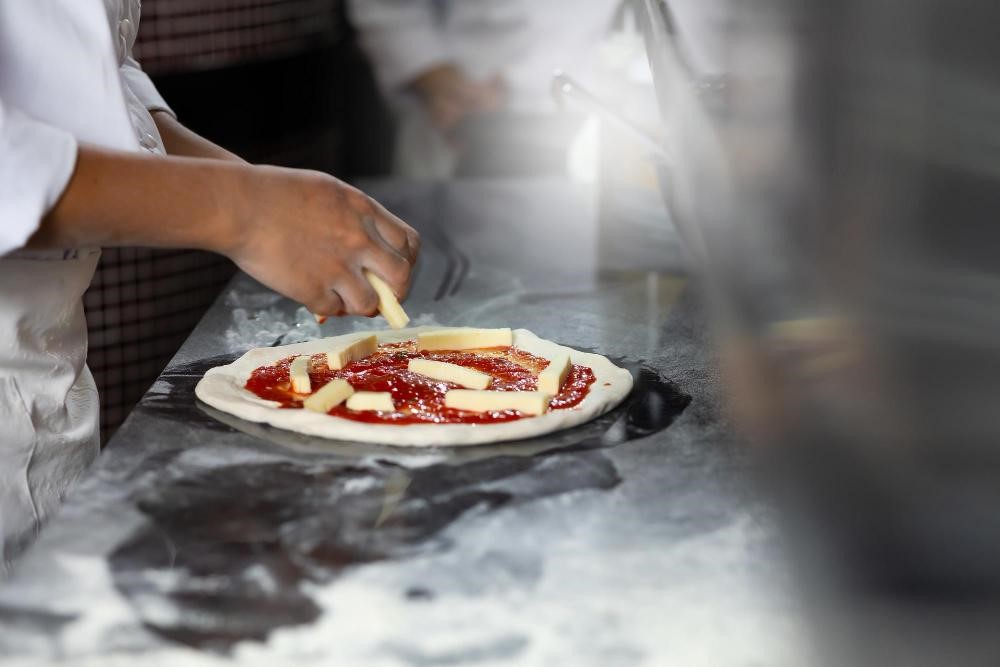 A pizzaiolo making Margherita pizza